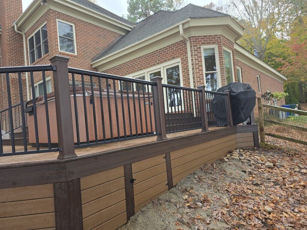 Brick house with wooden deck and grill.