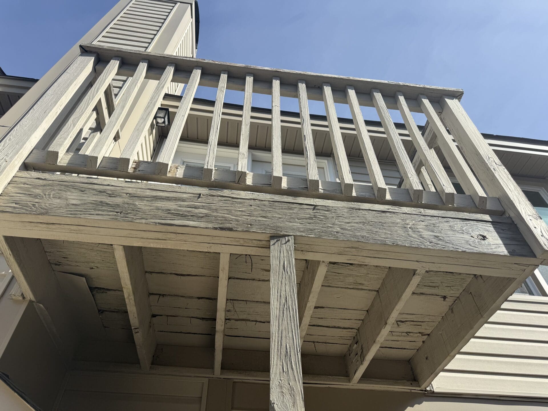 Elevated composite deck with railing in a spacious backyard, built by B&B Decks